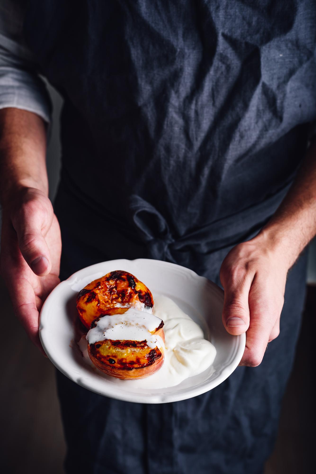 Instructor plating a seasonal dish in warm kitchen light
